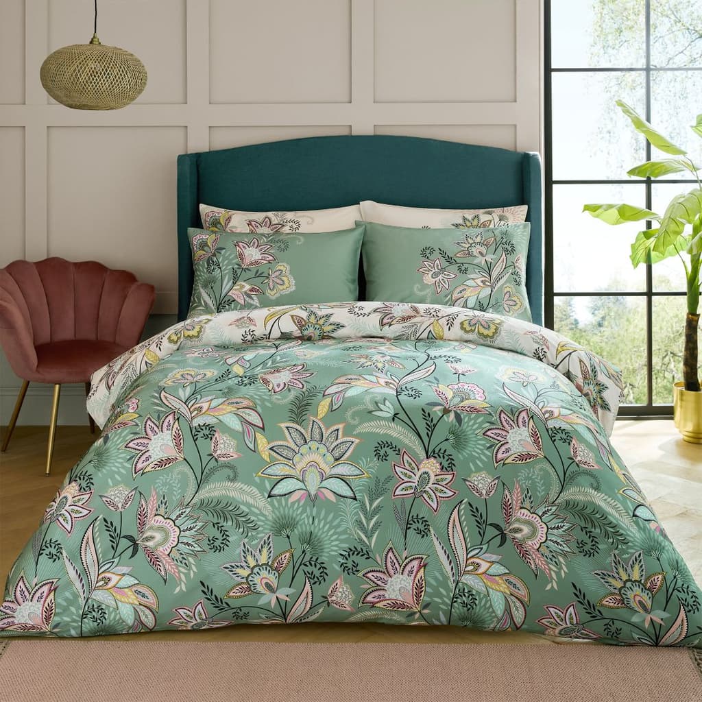 Sara Miller Passiflora Light Stone/Sage Duvet Cover on a bed with a pink chair